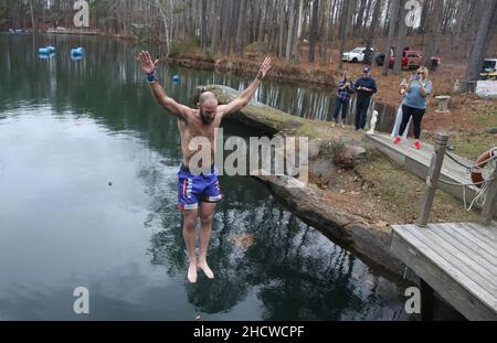 Wendell, North Carolina, USA. 1st Januar 2022. DALE MORRILL springt 50 Grad Mystery Lake, während Dutzende am fünften jährlichen Neujahrstag-Polar-Tauchgang im Mystery Lake Scuba Park in Wendell, North Carolina, teilnahmen. Alle Erlöse gehen an Mütter gegen betrunkenes Fahren (MADD). Der See ist ein 105 Meter tiefer Steinbruch, in dem einst in den 1920er Jahren Granit abgebaut wurde, um lokale Autobahnen zu bauen. (Bild: © Bob Karp/ZUMA Press Wire) Stockfoto