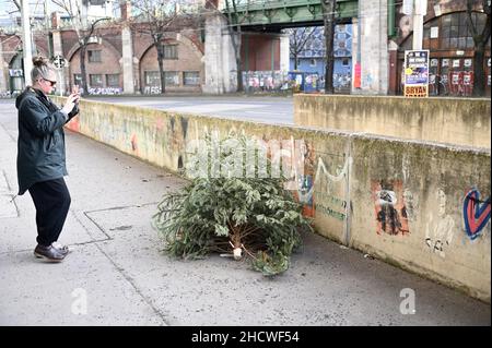 Weggeworfener Weihnachtsbaum liegt auf dem Bürgersteig Stockfoto