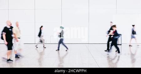 Verschwommene Pendler, die an einem Flughafen laufen Stockfoto