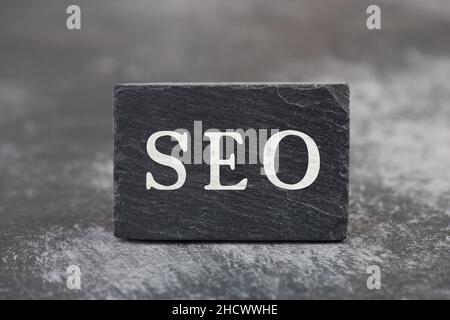 Das Wort SEO steht auf einem schwarzen Hintergrund, Website-Optimierung, Ranking-Strategie Stockfoto