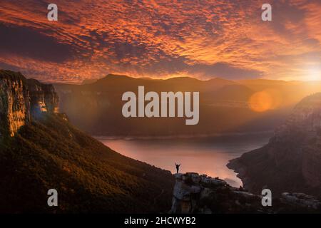 Silhouette einer abenteuerlichen Person, die eine beeindruckende Landschaft betrachtet. Fantastische Landschaft auf Morro de l'Abella, Osona, Barcelona, Katalonien. Beau Stockfoto