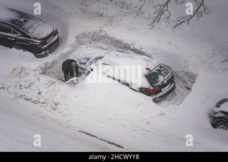 Aushub (Freigabe) des Wagens mit improvisierten Mitteln nach starkem Schneefall (manuelle Reinigung des Schnees in der Nähe des Wagens nach starkem Schneefall) Stockfoto