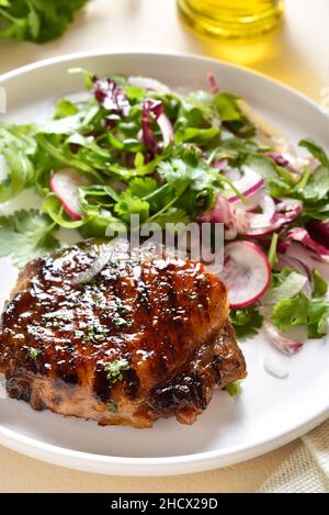 Gebratenes Schweinesteak mit Salat aus frischem Gemüse. Nahaufnahme Stockfoto