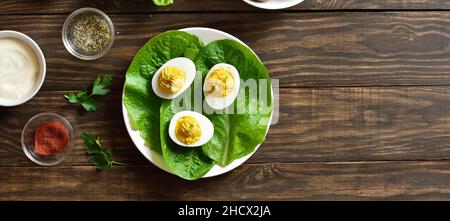Deviled Eier mit Paprika, Senf und Mayonnaise auf Teller über Holzhintergrund mit freien Text Raum. Draufsicht, flach liegend Stockfoto
