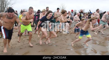 Racine, Wisconsin, USA. 1st Januar 2022. Schwimmer laufen am jährlichen Neujahrstag am Samstag, den 1. Januar 2022, in Racine, Wisconsin, in den See, wo der Eisbär Splash und Dash eintauchen. Der Erlös aus der Veranstaltung geht an lokale Wohltätigkeitsorganisationen, darunter eine Lebensmittelbank und ein Obdachlosenheim. Die Wassertemperatur lag bei 40 Grad, und der Windchill-Index bei 19 Grad. Der erste Schneesturm der Saison - mit 4 bis 8 Zoll vorhergesagt - begann kurz nach dem Ereignis. (Bild: © Mark Hertzberg/ZUMA Press Wire) Stockfoto