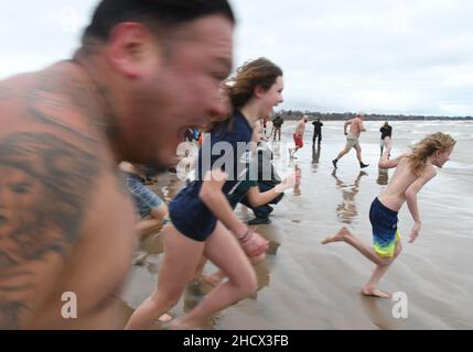 Racine, Wisconsin, USA. 1st Januar 2022. Schwimmer laufen am jährlichen Neujahrstag am Samstag, den 1. Januar 2022, in Racine, Wisconsin, in den See, wo der Eisbär Splash und Dash eintauchen. Der Erlös aus der Veranstaltung geht an lokale Wohltätigkeitsorganisationen, darunter eine Lebensmittelbank und ein Obdachlosenheim. Die Wassertemperatur lag bei 40 Grad, und der Windchill-Index bei 19 Grad. Der erste Schneesturm der Saison - mit 4 bis 8 Zoll vorhergesagt - begann kurz nach dem Ereignis. (Bild: © Mark Hertzberg/ZUMA Press Wire) Stockfoto