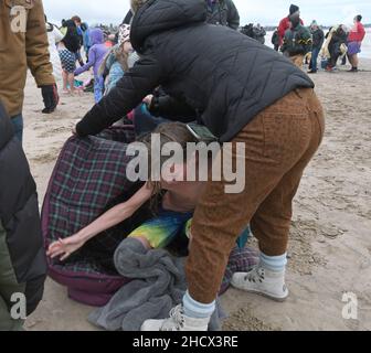 Racine, Wisconsin, USA. 1st Jan, 2022. Der jährliche New YearÃ¢â‚¬â„¢Day Splash and Dash Eisbär stürzt am Samstag, den 1. Januar 2022, in den Lake Michigan in Racine, Wisconsin. Der Erlös aus der Veranstaltung geht an lokale Wohltätigkeitsorganisationen, darunter eine Lebensmittelbank und ein Obdachlosenheim. Die Wassertemperatur lag bei 40 Grad, und der Windchill-Index bei 19 Grad. Der erste Schneesturm der seasonÃ¢â‚¬â„¢- mit 4 bis 8 Zoll vorhergesagt - begann kurz nach dem Ereignis. (Bild: © Mark Hertzberg/ZUMA Press Wire) Stockfoto