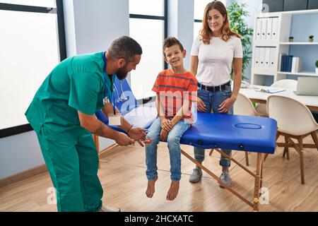 Familie mit ärztlicher Beratung, die einen Reflexknietest in der Klinik macht Stockfoto