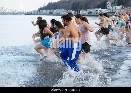 Seattle, Washington, USA. 1st. Januar 2022. Schwimmer stürzen sich beim jährlichen Eisbären-Schwimmen am Alki Beach Park. Quelle: Paul Christian Gordon/Alamy Live News Stockfoto