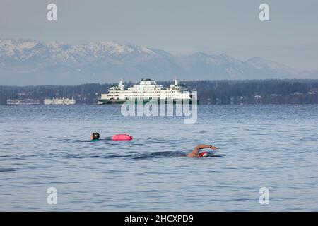 Seattle, Washington, USA. 1st. Januar 2022. Schwimmer im Freiwasser schwimmen im Alki Beach Park, dem jährlichen Eisbären von Alki Beach. Quelle: Paul Christian Gordon/Alamy Live News Stockfoto