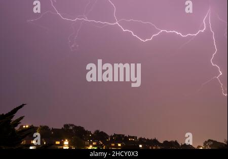 Gabelblitz im Himmel über der Stadt Stockfoto