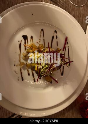 Leckeres Steak Mignon mit Gemüse und Kartoffeln gekrönt. Nahaufnahme eines Rindfleischtellers auf einem weißen Teller von oben. Stockfoto