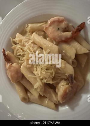 Leckere Pasta Carbonara mit Garnelen und Käse. Typisch italienisches Gericht auf einem weißen Teller aus der Nähe. Stockfoto