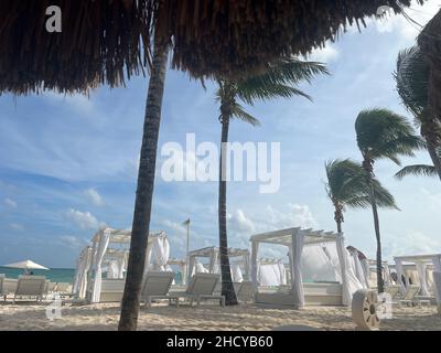 Weiße Liegestühle und Sonnenterrassen am Strand an der Riviera Maya, Mexiko. VIP Luxus Beach Club in einem tropischen Resort.