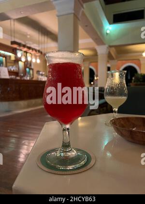 Daiquiri aus roter Erdbeere in einem Glas aus nächster Nähe trinken. Alkoholischer Cocktail in Glas in der Bar ohne Leute. Stockfoto