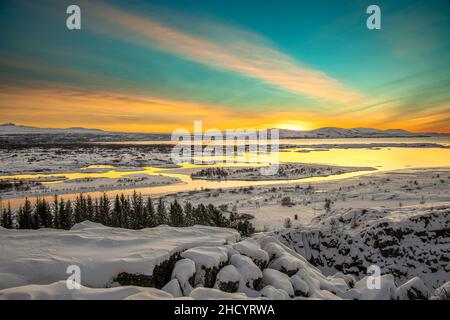 Die Morgendämmerung im Thingvellir Nationalpark bringt roten Himmel über weißeren Schnee. Stockfoto