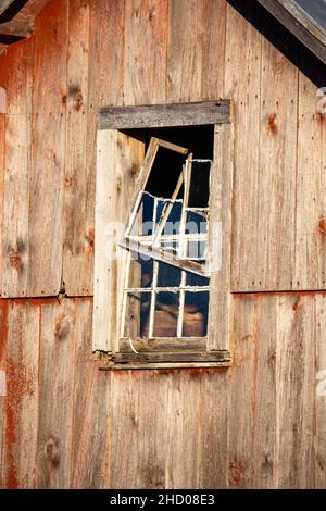 Rustikal gealterte Scheune Abstellgleis und kaputtes Fenster, vertikal Stockfoto