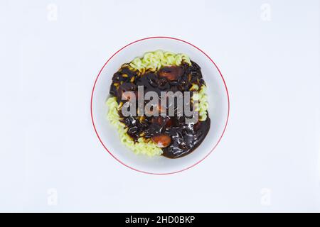 Eine flache Lay Shot aus köstlichem koreanischem Noodle namens Jjajangmyeon mit Würsten als Topping auf dem weißen Hintergrund Stockfoto