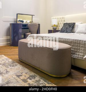 Studioaufnahme eines modernen Zimmers mit komfortablem Bett und Nachttisch mit Lampe Stockfoto