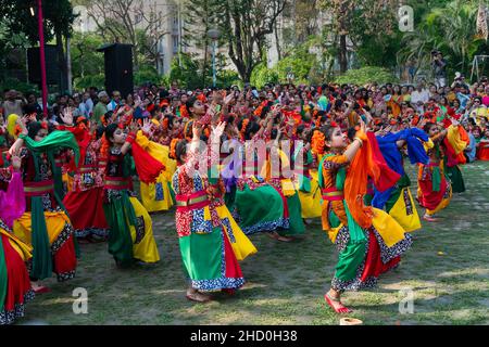 Kalkutta, Indien - 21.. März 2019: Tanzende Mädchen, bekleidet mit farbenfrohem Sari (traditionelles indisches Kleid) und Palashblumen (Butea monosperma). Stockfoto