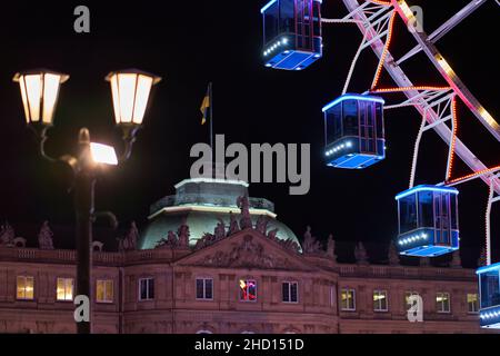 Stuttgart, 31. Dezember 2021: Nahaufnahme der Riesenradgondeln vor einem Schloss. Straßenlaterne im Vordergrund nicht fokussiert. Attraktion Stockfoto