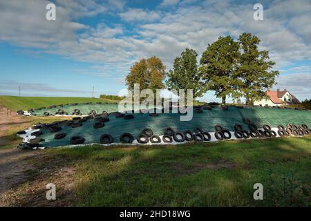 Ländliche Landschaft mit einem Hügel von Tierfutter. Stockfoto