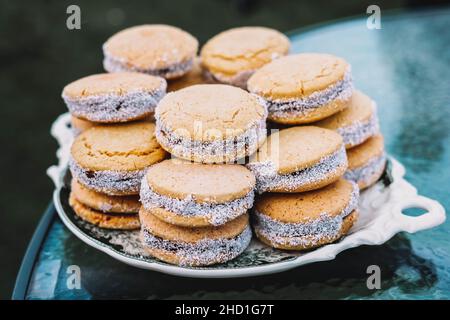 Ein Teller voller Maisstärke-Alfajores gefüllt mit Dulce de leche. Typisch südamerikanisches Dessert. Stockfoto