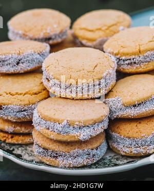 Ein Teller voller Maisstärke-Alfajores gefüllt mit Dulce de leche. Typisch südamerikanisches Dessert. Stockfoto