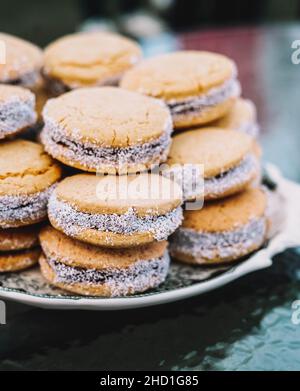 Ein Teller voller Maisstärke-Alfajores gefüllt mit Dulce de leche. Typisch südamerikanisches Dessert. Stockfoto