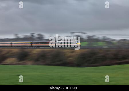 Intercity Lackierung elektrische Lokomotive der Baureihe 90 90002, die einen Intercity-Charterzug auf der Hauptlinie der Westküste mit hoher Geschwindigkeit und Bewegungsunschärfe schleppt Stockfoto