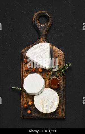 Blick von oben auf die Käseplatte. Sortiment aus Brie und Camembert Käse auf Holzschneidebrett. Stockfoto