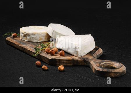 Käseplatte. Sortiment aus Brie und Camembert Käse auf Holzschneidebrett. Stockfoto