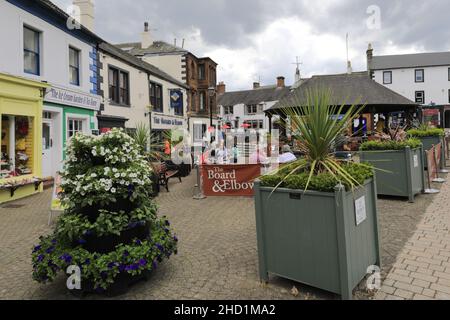 Personen außerhalb des Verwaltungsrats und des Elbow Pub, Penrith Town, Cumbria, England, Großbritannien Stockfoto