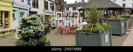 Personen außerhalb des Verwaltungsrats und des Elbow Pub, Penrith Town, Cumbria, England, Großbritannien Stockfoto