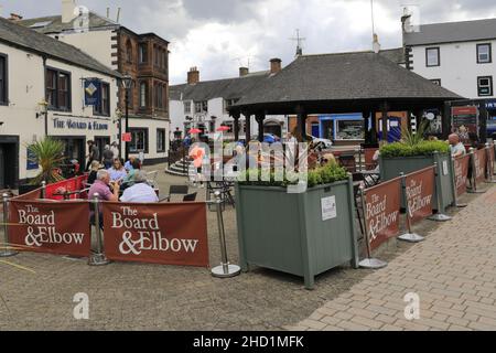 Personen außerhalb des Verwaltungsrats und des Elbow Pub, Penrith Town, Cumbria, England, Großbritannien Stockfoto