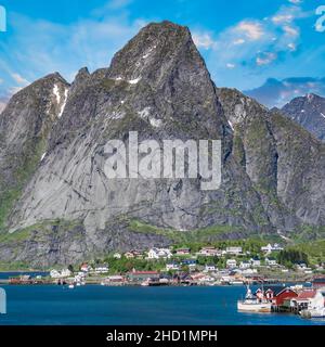 Reine, Lofoten, Norwegen - Juni 2016: Das Fischerdorf reine unter einem sonnigen, blauen Himmel mit den typischen Rorbu-Häusern. Die Stadt befindet sich über dem Bogen Stockfoto