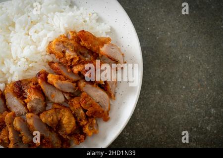 Gebratenes Schweinefleisch auf Reis mit würziger Dip-Sauce gekrönt Stockfoto