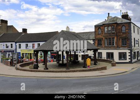 Personen außerhalb des Verwaltungsrats und des Elbow Pub, Penrith Town, Cumbria, England, Großbritannien Stockfoto