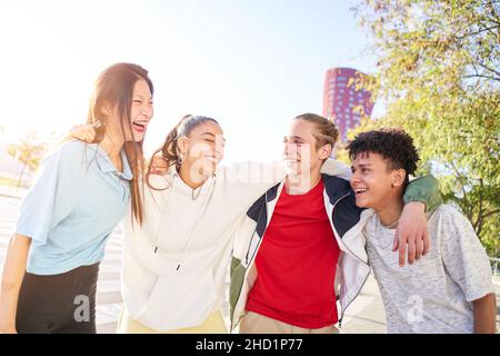Multirassische Gruppe junger Studenten, die lachen und umarmen. Menschen mit Spaß und Freundschaft Konzept. Stockfoto