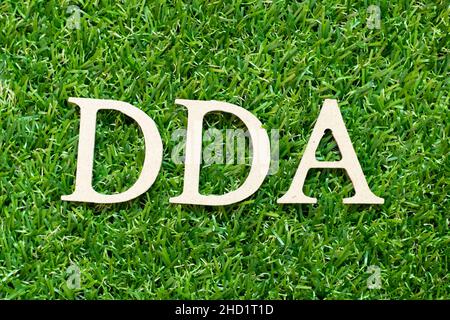 Buchstabenbuchstabe in Wort DDA (Abkürzung für Abschreibung, Erschöpfung und Abschreibung oder Einlagenkonto) auf grünem Gras Hintergrund Stockfoto