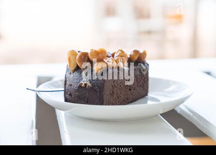 Macadamia Schokoladenkuchen auf weißem Teller Stockfoto