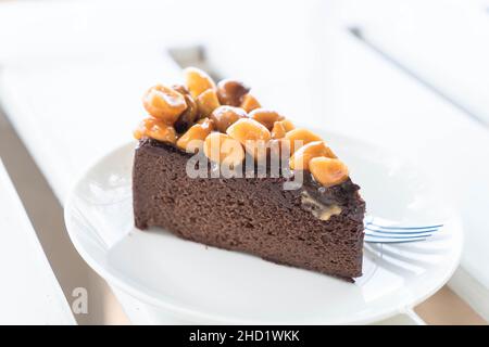 Macadamia Schokoladenkuchen auf weißem Teller Stockfoto