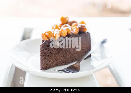 Macadamia Schokoladenkuchen auf weißem Teller Stockfoto