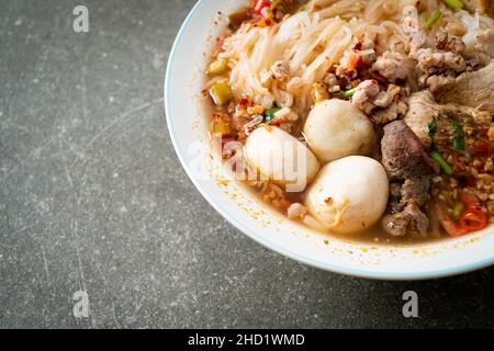 Nudeln mit Schweinefleisch und Fleischbällchen in würziger Suppe oder Tom-Yum-Nudeln im asiatischen Stil Stockfoto