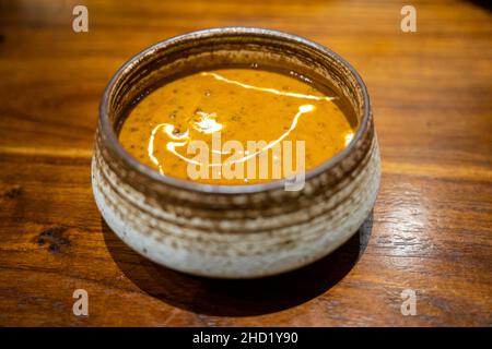 Eine Schüssel mit köstlichem Dal makhani, indischem Linsencryl mit Creme auf einem Holztisch Stockfoto