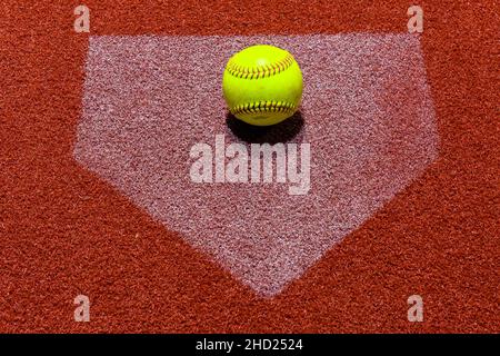 Aufnahme eines Softballs über dem Kopf auf der Matte auf rotem Grund Stockfoto