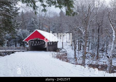 Die Flume Covered Bridge im Franconia Notch State Park in Lincoln, New Hampshire, ist an einem Wintermorgen schneebedeckt. Diese malerische Brücke überquert Stockfoto