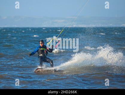 Longniddry, East Lothian, Schottland, Großbritannien. 2nd. Januar 2022. Stürmischer Wind mit 20 km/h und möglichen Böen von 35 km/h Temperatur von 8 Grad für die wenigen Kitesurfer, die sich auf den rauhen Firth of Forth wagten. Die Bedingungen gaben den erfahrenen Surfern gutes Potenzial, gute Luft zu bekommen. Credit: Arch White Stockfoto