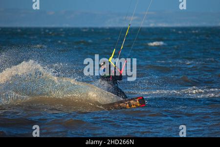 Longniddry, East Lothian, Schottland, Großbritannien. 2nd. Januar 2022. Stürmischer Wind mit 20 km/h und möglichen Böen von 35 km/h Temperatur von 8 Grad für die wenigen Kitesurfer, die sich auf den rauhen Firth of Forth wagten. Die Bedingungen gaben den erfahrenen Surfern gutes Potenzial, gute Luft zu bekommen. Credit: Arch White Stockfoto