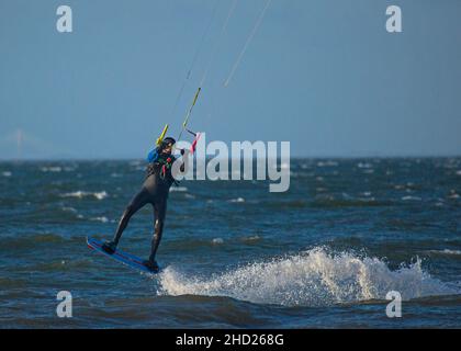Longniddry, East Lothian, Schottland, Großbritannien. 2nd. Januar 2022. Stürmischer Wind mit 20 km/h und möglichen Böen von 35 km/h Temperatur von 8 Grad für die wenigen Kitesurfer, die sich auf den rauhen Firth of Forth wagten. Die Bedingungen gaben den erfahrenen Surfern gutes Potenzial, gute Luft zu bekommen. Credit: Arch White Stockfoto